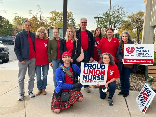 Group of nurses outside with "proud union nurses" sign
